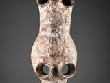 un gros plan d'un vase troué posé sur une surface grise