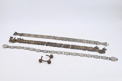 trois bracelets en argent et une bague posés sur un fond blanc
