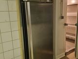 a stainless steel refrigerator in the corner of a kitchen