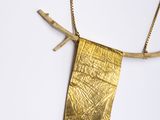 a close up of a gold necklace on a white surface