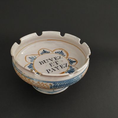 a blue and white bowl on a table with a black background