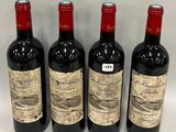 three bottles of red wine are lined up on a table