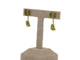 pair of peridot earrings on display on a stand