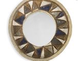 a small round mirror with a blue and white design on it