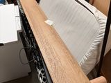 une photo d'un lit dans une chambre où se trouvent de nombreux cartons