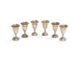 un ensemble de cinq gobelets et tasses en argent sur fond blanc