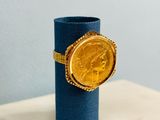 a gold coin sitting on a blue cylinder on a table