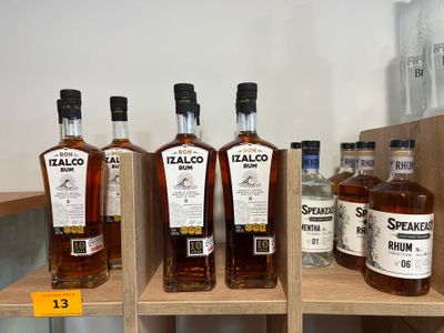 Plusieurs bouteilles d'alcool sont posées sur une étagère dans un magasin.