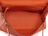 the inside of an orange purse with a zipper on it