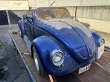 a blue car that is being loaded onto a trailer