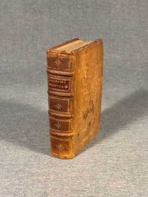 an old book sitting on top of a table next to a gray surface