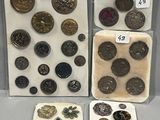 Plusieurs types de boutons et d'aimants sont exposés dans une vitrine.