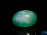 an image of a green jade stone sitting on top of a black surface