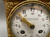 a gold clock that is sitting on a table