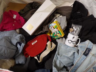 a pile of clothes and other items on a bed