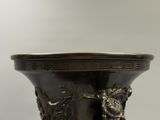 un vase en bronze orné d'une tête de lion