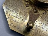 a close up of a metal object with a clock on it