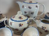 a white table with a bunch of blue and white dishes and cups