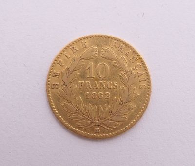 gros plan d'une pièce d'or sur une surface blanche