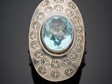 un gros plan d'une bague en argent sertie d'une topaze bleue