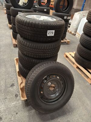 several tires are stacked on pallets in a warehouse area