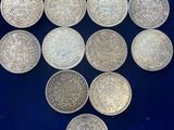 six silver coins are arranged in a triangle on a blue surface