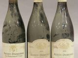 trois bouteilles de vin posées l'une à côté de l'autre sur une table