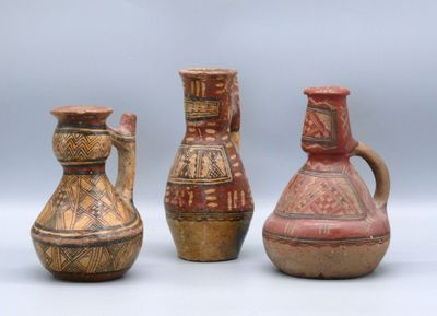 three vases sitting next to each other on a white surface