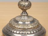 a silver vase on a wooden table with a gray background
