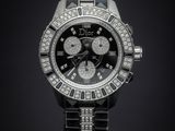 a close up of a watch on a black surface with a black background