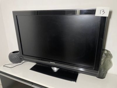 une télévision à écran plat posée sur une table blanche