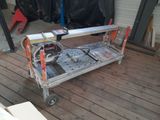 une petite table sur laquelle est posée une scie, posée elle-même sur un plancher en bois
