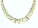a close up of a gold necklace on a white background
