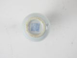 a white bowl with a blue lid on a white table