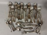 un grand nombre de cuillères et de fourchettes en argent disposées sur une table