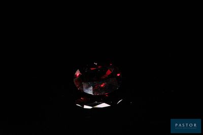 un gros plan d'un diamant rouge sur fond noir