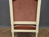 an old chair sitting on top of a wooden floor next to a gray wall