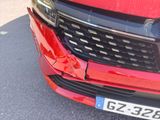 a close up of a red car with a number plate on the front of it