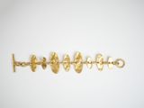 a close up of a gold bracelet on a white surface