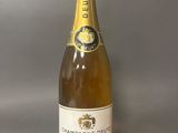 La bouteille de champagne est posée sur la table.