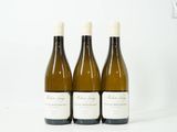 trois bouteilles de vin posées sur une table l'une à côté de l'autre