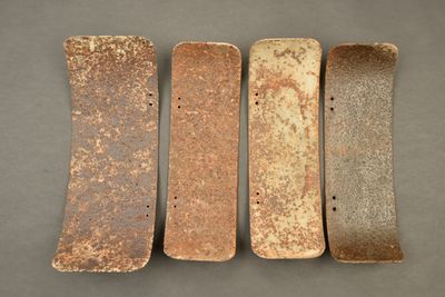 four skateboards are lined up in a row on a gray surface