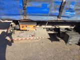 a blue truck with a metal box on the back of it