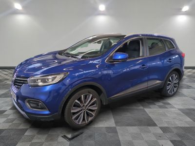 un 4x4 bleu garé sur un sol en damier dans un garage