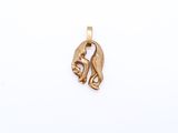 a close up of a gold pendant on a white surface