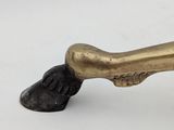 an image of a bronze figurine of a dog ' s paw holding a bone
