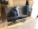 a flat screen tv sitting on the floor next to a pile of boxes