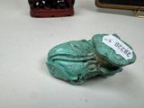 a small statue of a frog with a tag on it