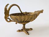 a metal bowl with a bird on it on a stand