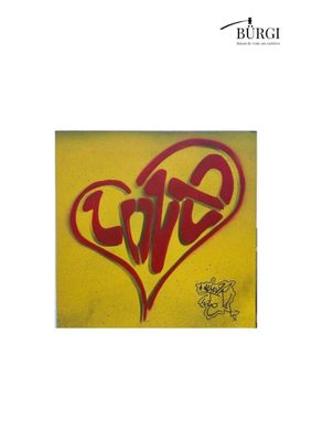 un graffiti représentant un cœur sur lequel est écrit le mot « amour »
